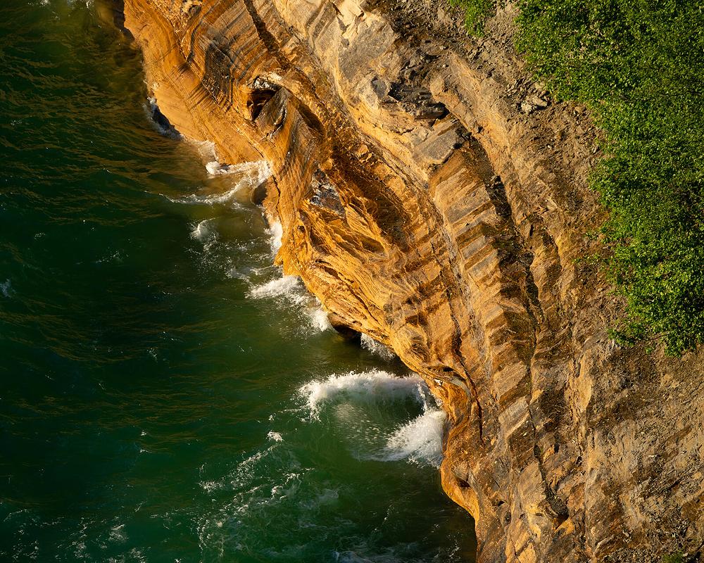 aerial view overlooking crashing waves on rocky cliffs